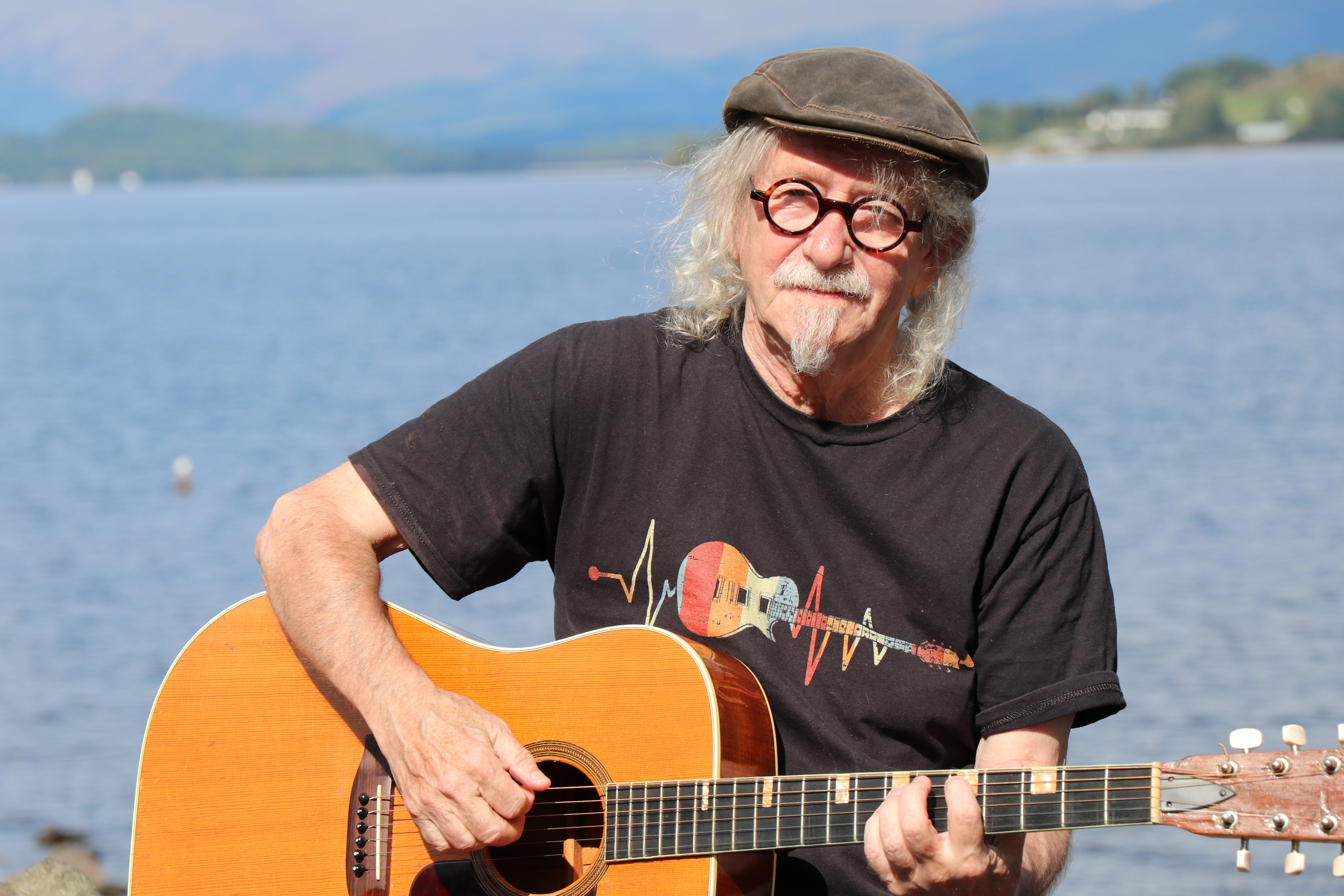 Joe Quinn playing guitar by the lake